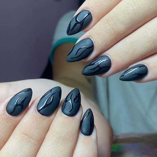 Uñas negras mate con diseño abstracto brillante