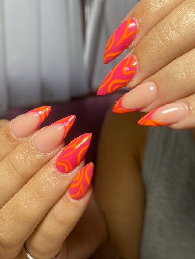 Uñas stiletto rosa y naranja con diseño de líneas